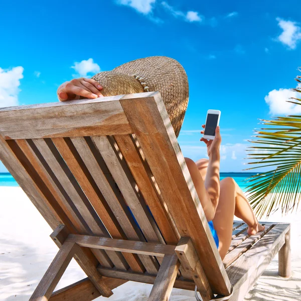 Kobieta z telefonem komórkowym na plaży — Zdjęcie stockowe