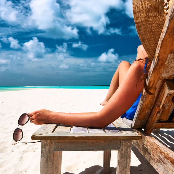 Женщина на пляже держит солнцезащитные очки — стоковое фото