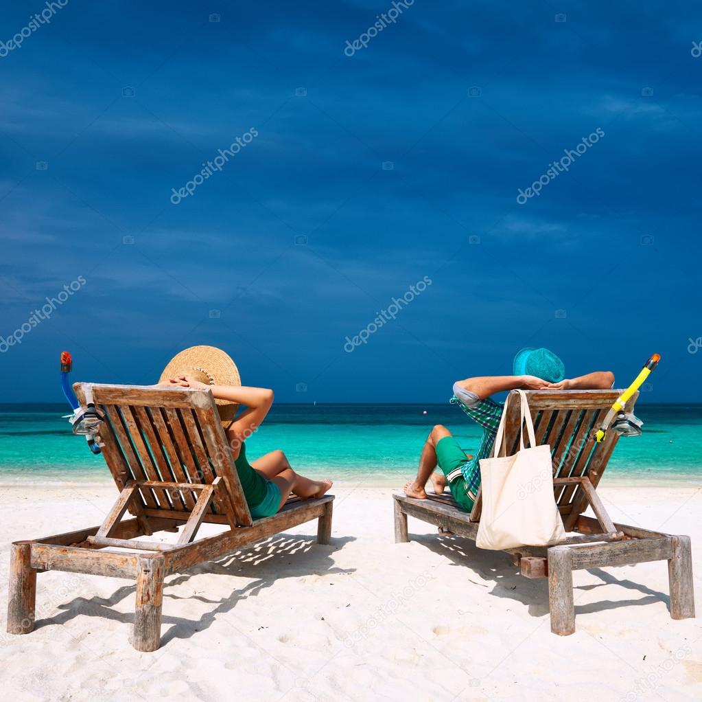 Couple relax on beach at Maldives