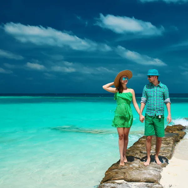 Couple in green on beach — Stock Photo, Image