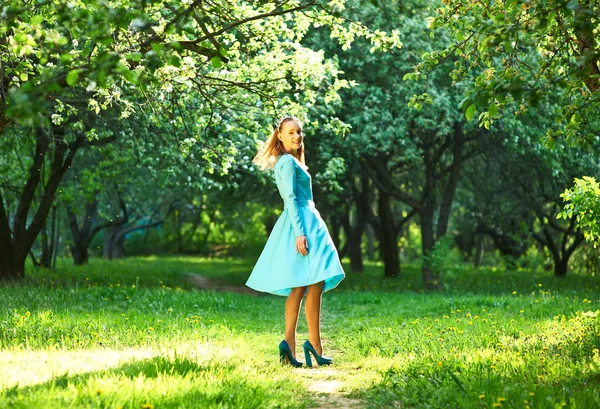 Žena v šatech mezi jabloňové květy — Stock fotografie