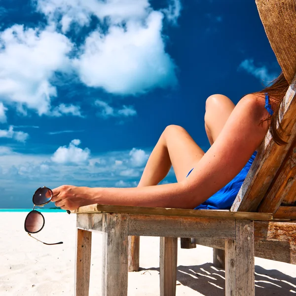 Mujer en la playa sosteniendo gafas de sol — Foto de Stock