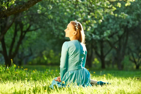 Mujer vestida entre flores de manzana — Foto de Stock