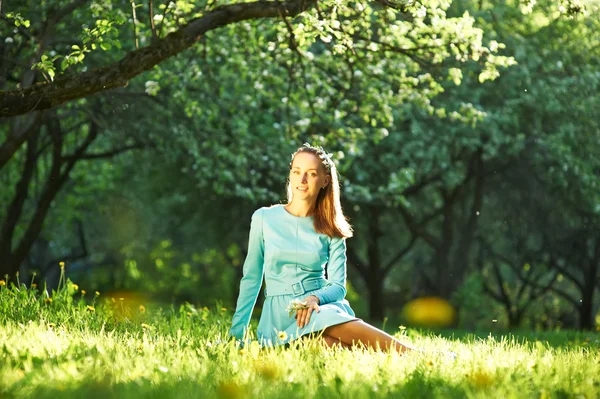 Frau im Kleid sitzt auf Gras — Stockfoto