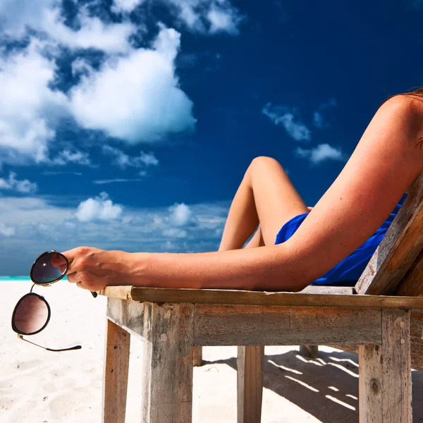 Femme à la plage tenant des lunettes de soleil — Photo