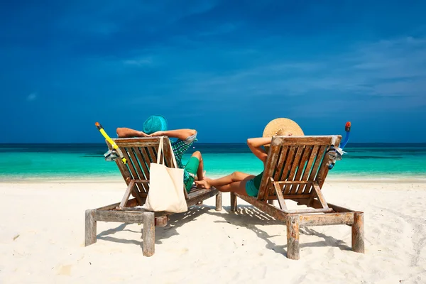 Coppia immersa nel verde rilassarsi su una spiaggia alle Maldive — Foto Stock