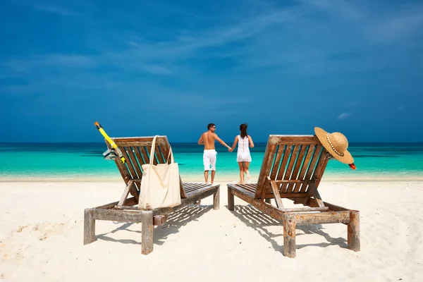 Coppia in bianco che corre su una spiaggia — Foto Stock