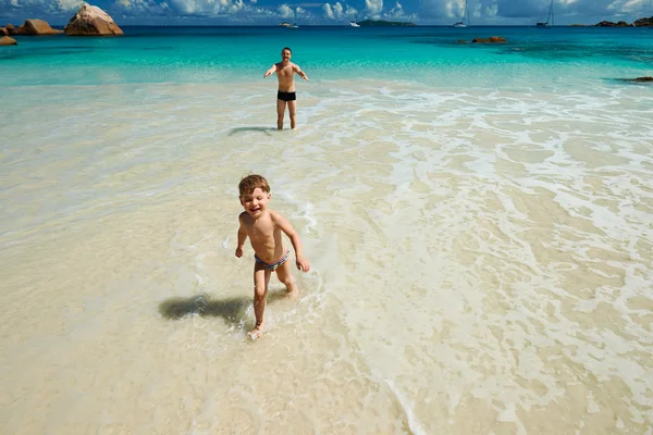 Far och son som spelar på stranden — Stockfoto