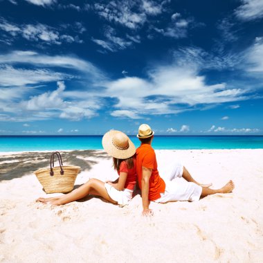 Couple relaxing on tropical beach clipart