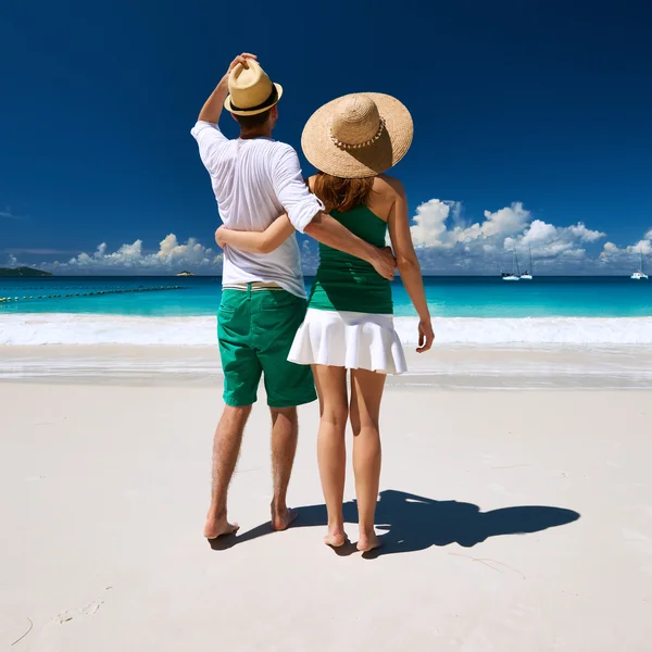 Pareja en verde caminando en la playa —  Fotos de Stock