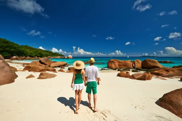 Couple in green walking on beach — Stock Photo, Image