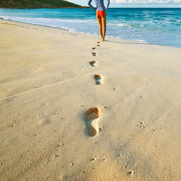 Pasos femeninos en la playa de arena — Foto de Stock