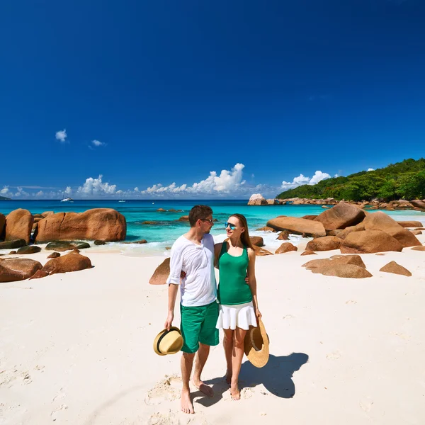 Casal em verde andando na praia — Fotografia de Stock