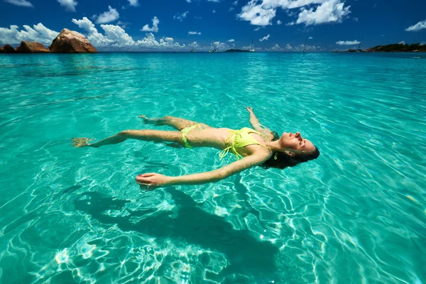 Vrouw in gele bikini op water — Stockfoto