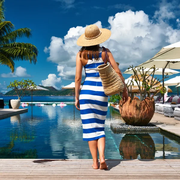 Mulher em vestido listrado perto da piscina — Fotografia de Stock