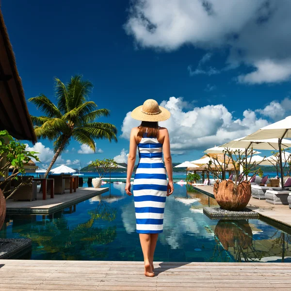 Kvinna i randig klänning nära vid poolen — Stockfoto