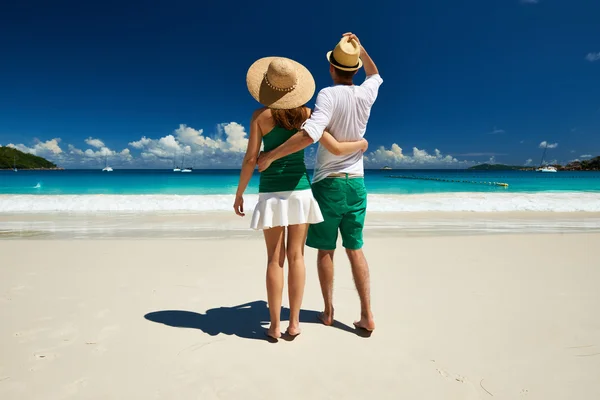 Casal em verde andando em uma praia — Fotografia de Stock