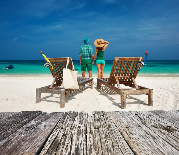 Par i grönt koppla av på en strand — Stockfoto