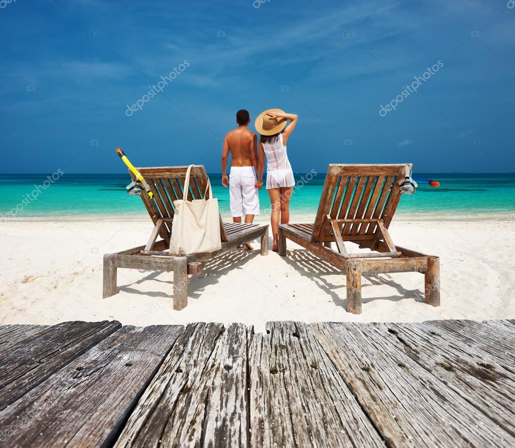 Couple in white relax on beach