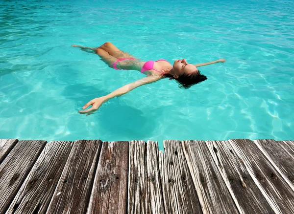 Woman in bikini lying on water — Stock Photo, Image