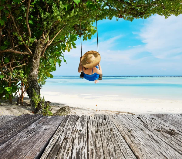 Женщина в синем платье качается на пляже — стоковое фото