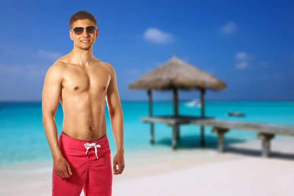 Mężczyzna na plaży z pomostem — Zdjęcie stockowe