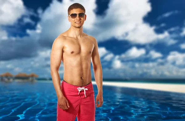 Man at tropical swimming pool — Stock Photo, Image