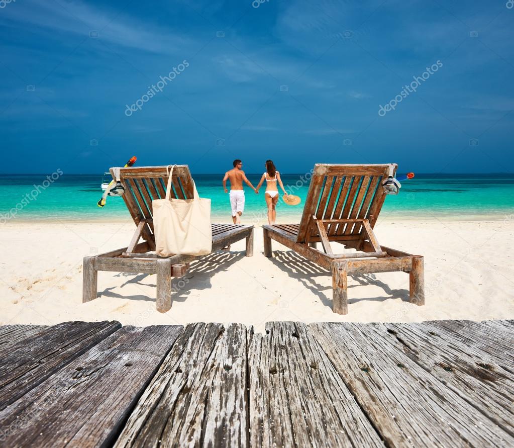 Couple in white relax on beach