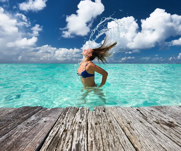 Woman splashing water with hair in the ocean — Stock Photo, Image