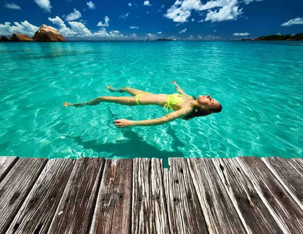 Donna in bikini sdraiata sull'acqua — Foto Stock