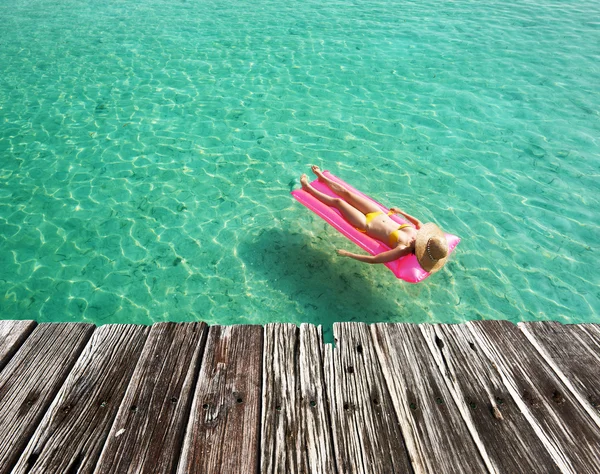 Mulher que relaxa no colchão inflável — Fotografia de Stock