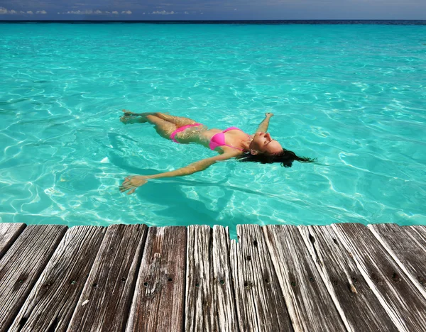 Frau im Bikini liegt auf dem Wasser — Stockfoto