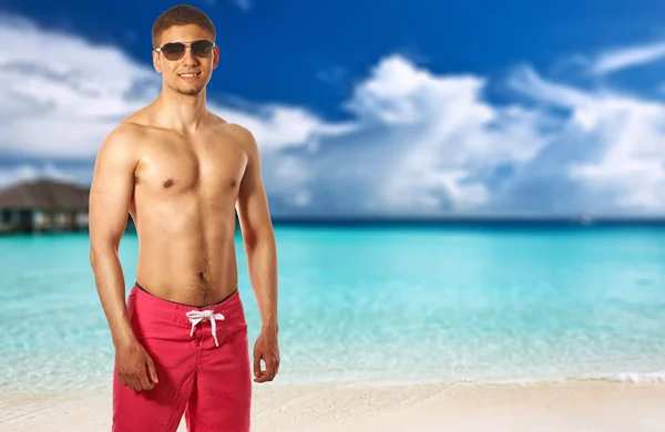 Uomo in spiaggia con bungalow d'acqua — Foto Stock