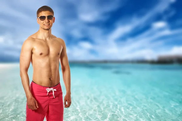 Uomo in spiaggia con bungalow d'acqua — Foto Stock