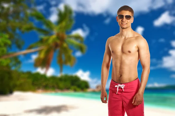 Man op het strand met een palmboom — Stockfoto