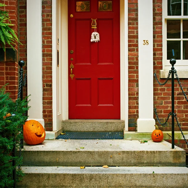 Dynie w pobliżu drzwi na Halloween — Zdjęcie stockowe