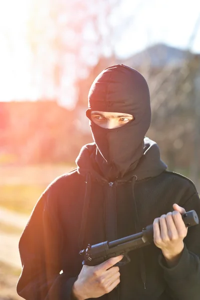 Pistolero en máscara negra con pistola — Foto de Stock