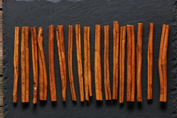 Cinnamon sticks on slate — Stock Photo, Image