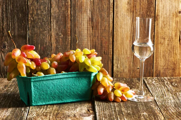 Ripe tasty grapes with glass of grappa — Stock Photo, Image