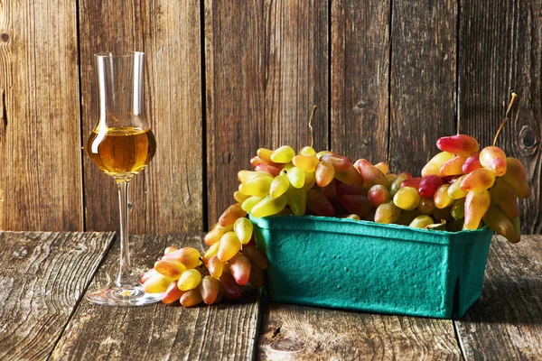 Ripe tasty grapes with glass of grappa — Stock Photo, Image