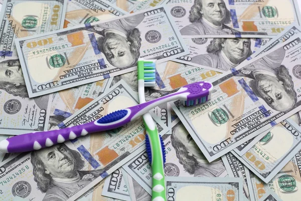 Two toothbrushes on money — Stock Photo, Image