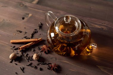 Ahşap bir masada çay ile cam çaydanlık.