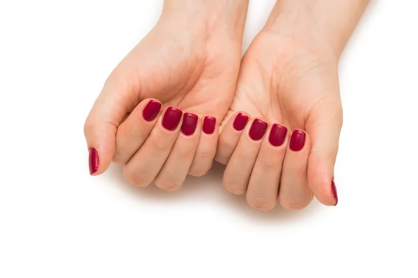 Mani donna con chiodo rosso isolato su bianco — Foto Stock