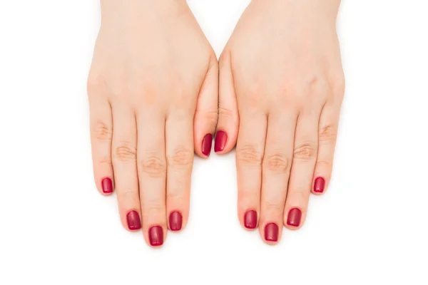 Beyaz çivili kırmızı tırnaklı kadın elleri — Stok fotoğraf