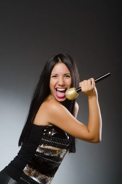 Ung kvinna sjunger i karaokeklubben — Stockfoto