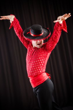 Kırmızı elbiseli bir adam İspanyol dansı yapıyor.