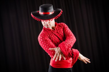 Kırmızı elbiseli bir adam İspanyol dansı yapıyor.