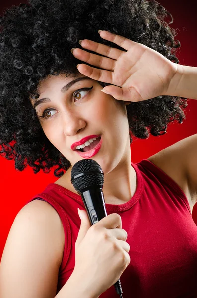 Mulher com penteado afro cantando em karaoke — Fotografia de Stock