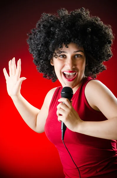 Vrouw met afro kapsel zingen Karaoke — Stockfoto