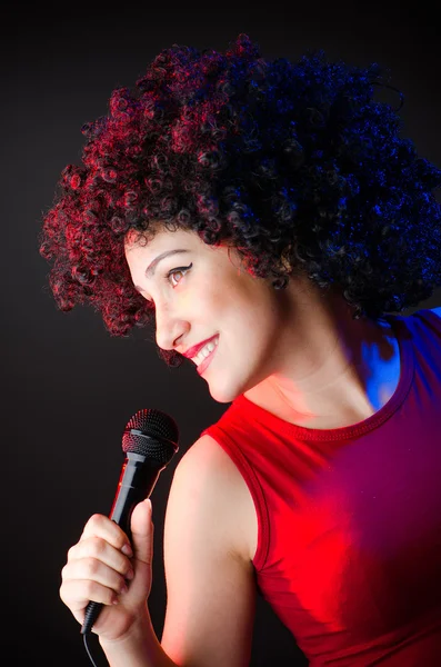 Mulher com penteado afro cantando em karaoke — Fotografia de Stock